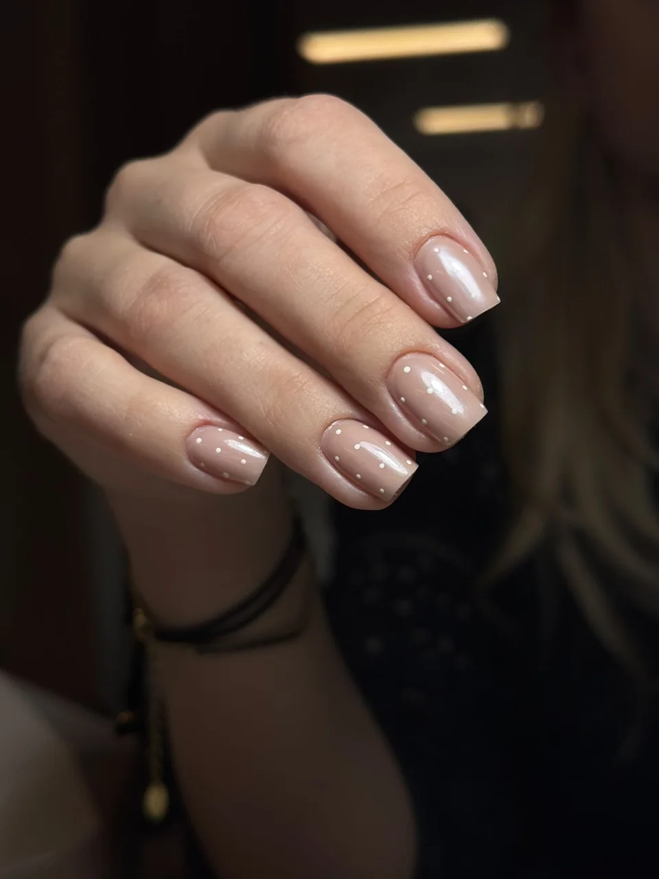 Subtelny manicure nude z białymi kropeczkami
